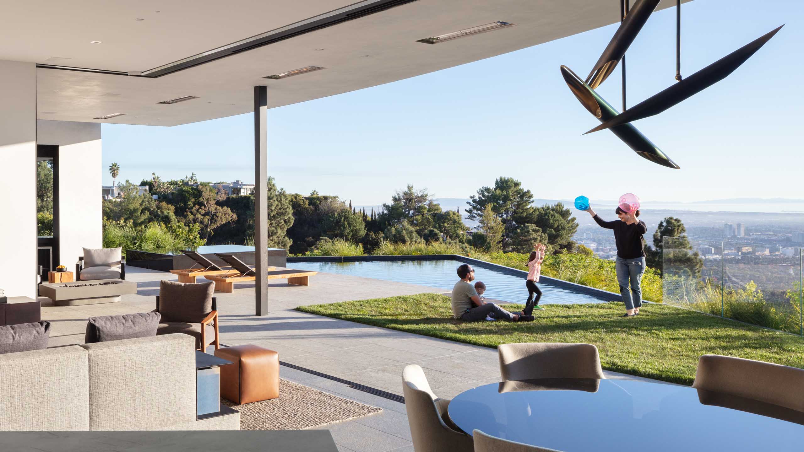 Living room with a seamless open connection to the yard, landscape, and pool