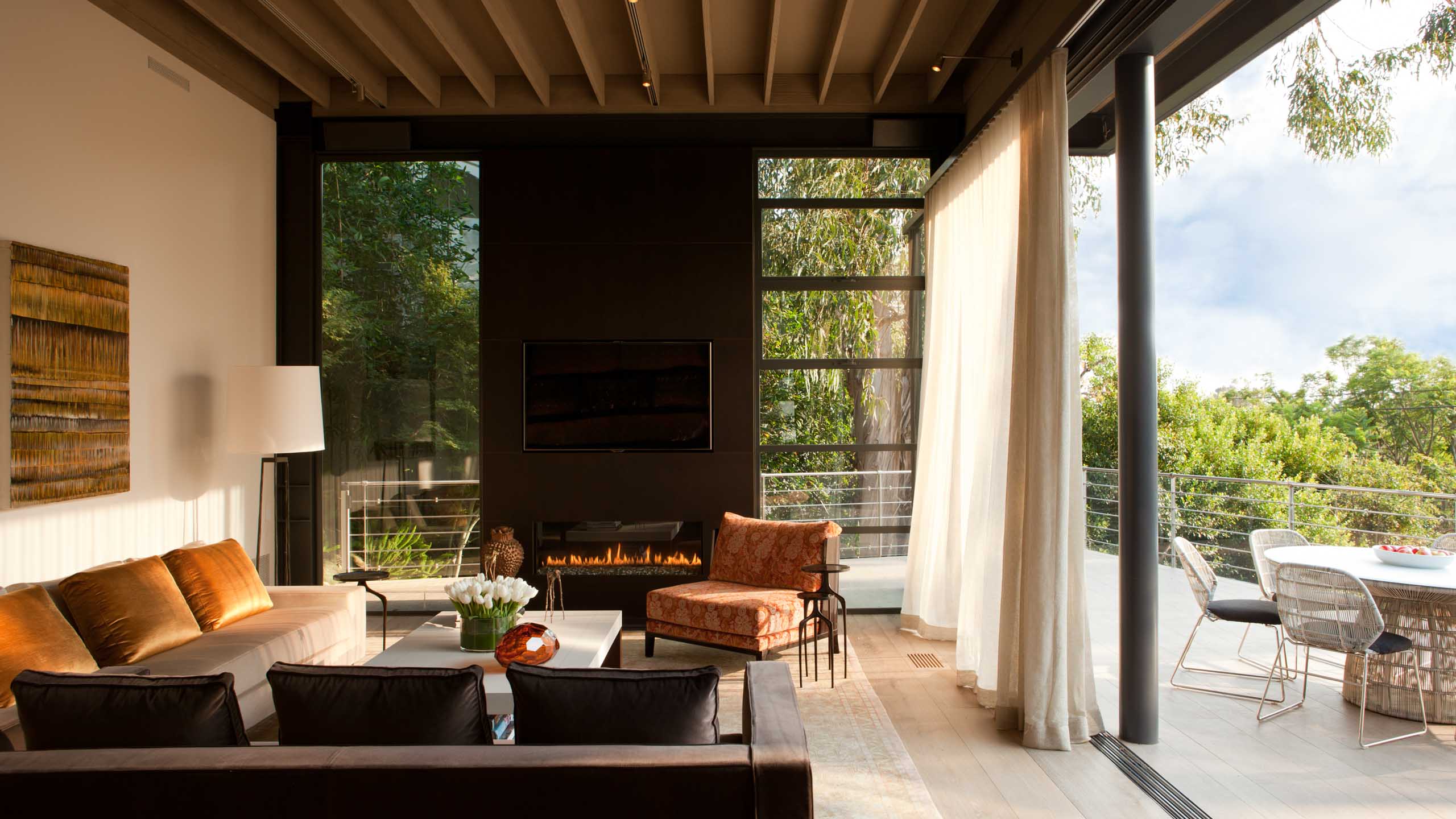 Living room open to the outdoor deck with bronze and gold furniture